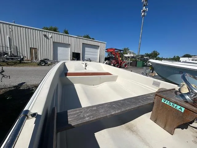 Slide: The Image of 1974 Boston Whaler 13 Sport boat in a storage yard, showcasing interior and steering console. - 2