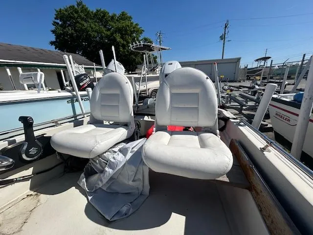 Slide: The Image of 1974 Boston Whaler 13 Sport boat with white seats, docked under clear blue sky. - 7