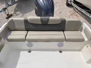 Slide: The Image of 2025 Key West 239 FS boat seating area with cushioned bench and motor in background. - 12