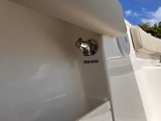 Slide: The Image of Freshwater outlet on 2025 Key West 239 FS boat, white exterior, blue sky background. - 20