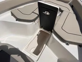 Slide: The Image of 2025 Key West 239 FS boat with open storage compartment and cushioned seating. - 38