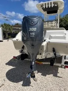 Slide: The Image of 2025 Key West 239 FS boat with a 300 V6 outboard motor, parked on gravel. - 6