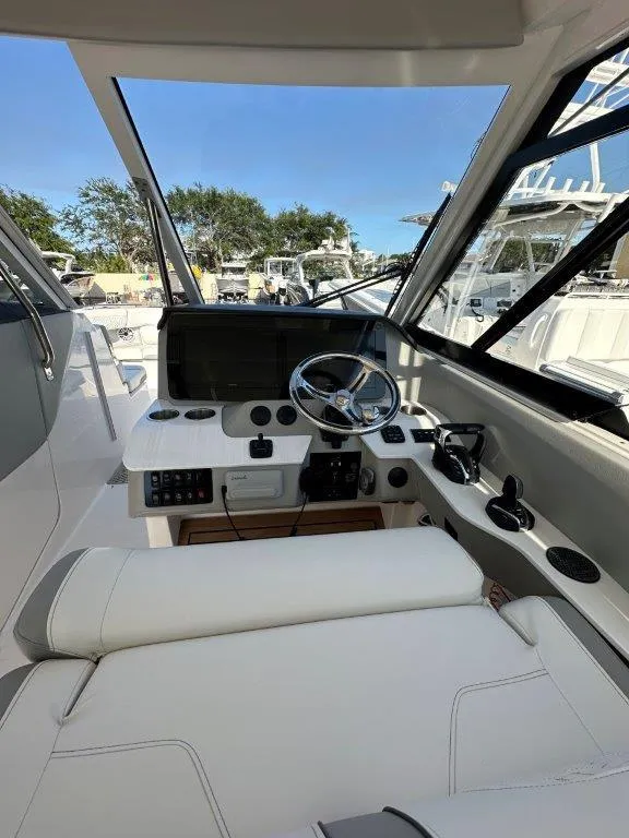 Slide: The Image of 2023 Regal LX36 boat cockpit with modern controls and steering wheel. - 14