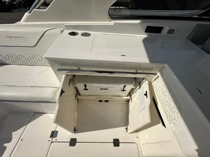 Slide: The Image of 2023 Regal LX36 boat interior with open storage compartment and sleek white design. - 19