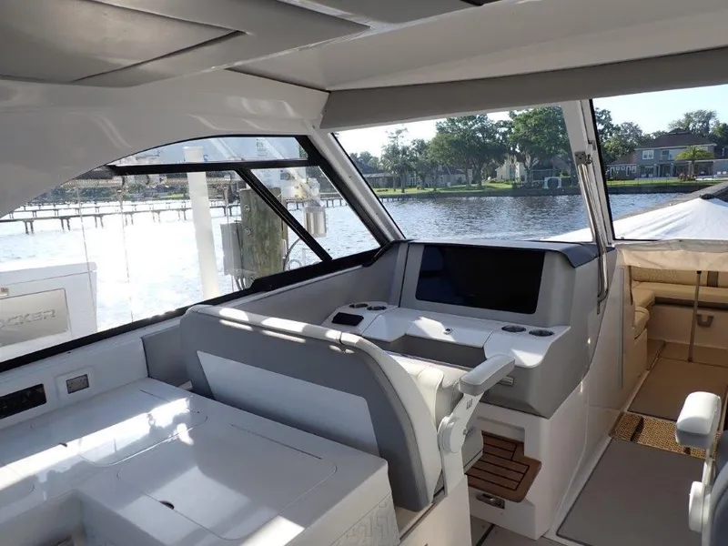 Slide: The Image of 2023 Regal LX36 boat interior with modern seating and waterfront view. - 25