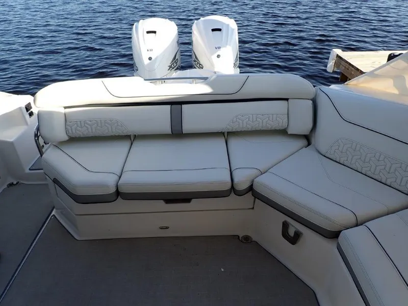 Slide: The Image of 2023 Regal LX36 boat with luxurious white seating and twin engines on a calm lake. - 30