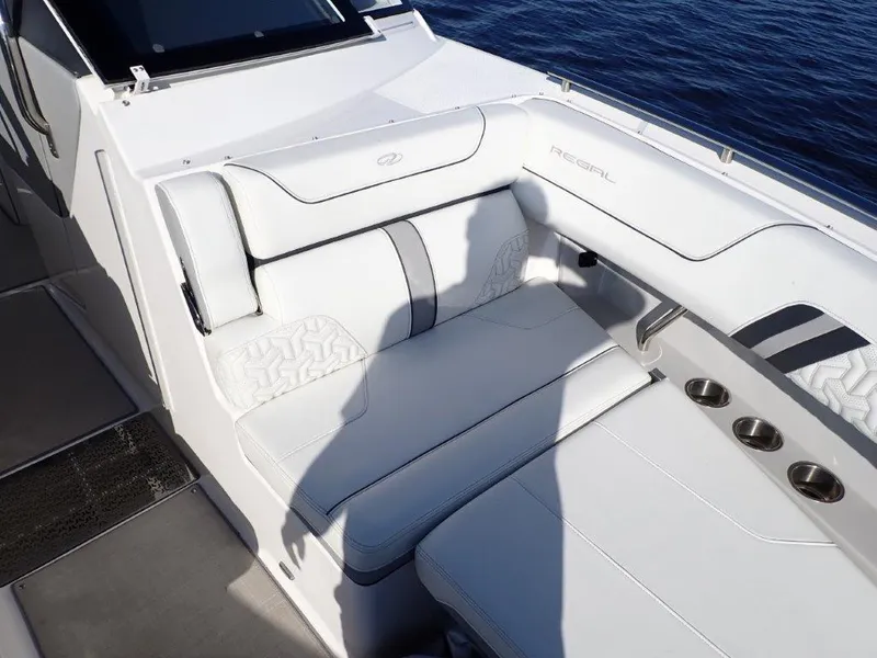 Slide: The Image of 2023 Regal LX36 boat with white leather seating and cup holders on deck. - 36
