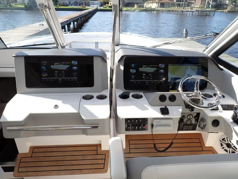 Slide: The Image of 2023 Regal LX36 boat cockpit with dual screens and wooden flooring. - 38