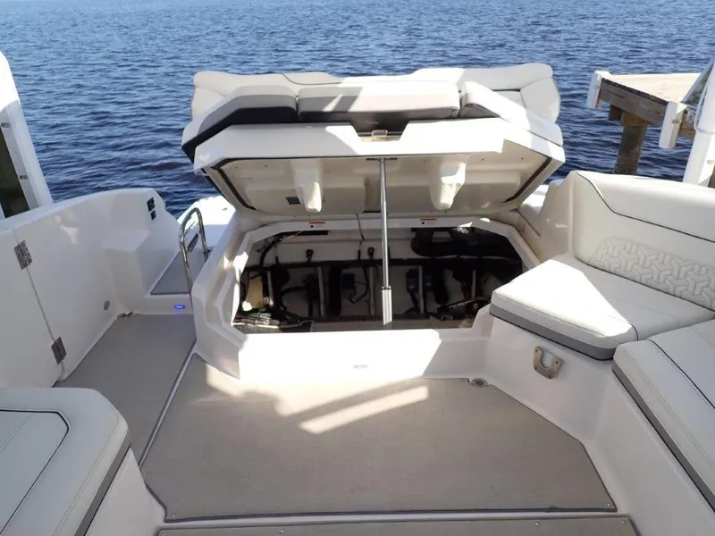 Slide: The Image of 2023 Regal LX36 boat with open storage compartment, docked by the water. - 39