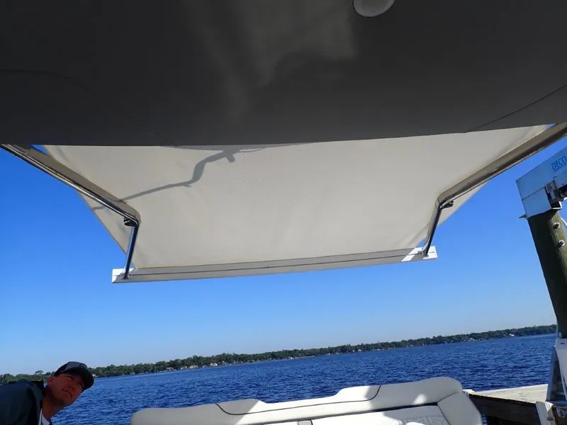 Slide: The Image of 2023 Regal LX36 boat with canopy, on a sunny day by the water. - 40