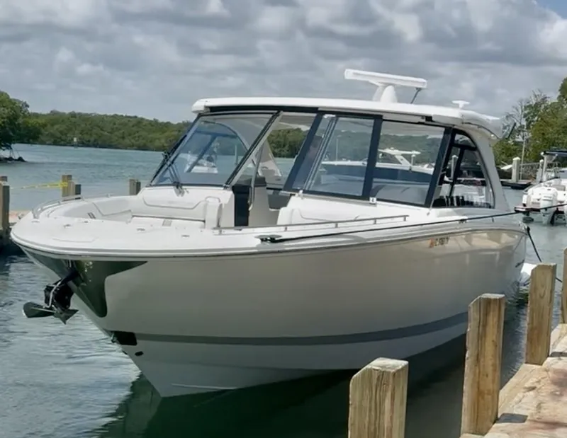 Slide: The Image of 2023 Regal LX36 boat docked by a scenic waterfront. - 7