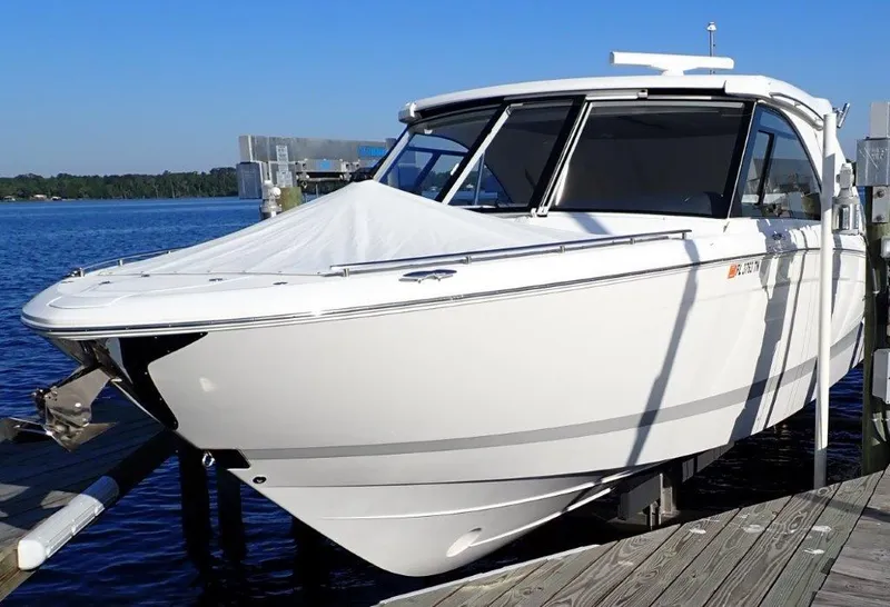 Slide: The Image of 2023 Regal LX36 boat docked by the water on a sunny day. - 8