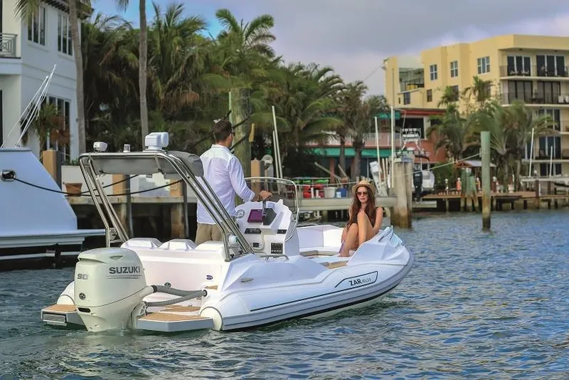 Slide: The Image of Zar Formenti 49 SL boat cruising near waterfront homes, 2025 model. - 3