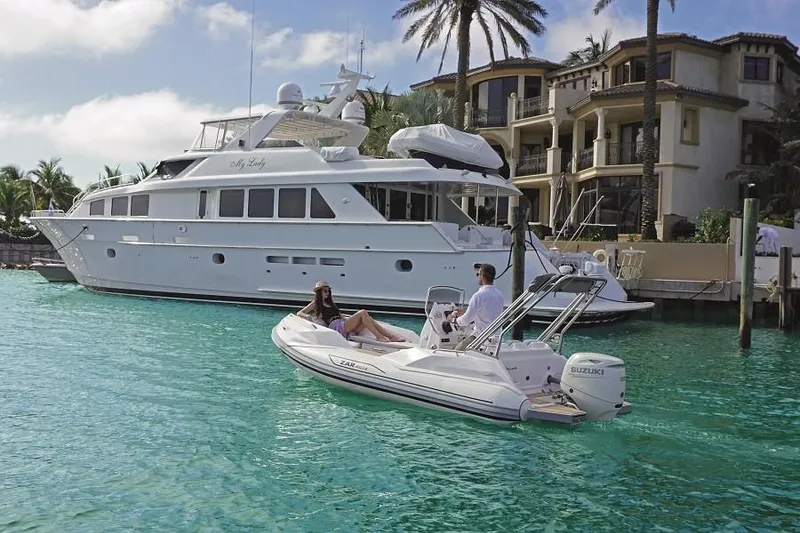 Slide: The Image of Zar Formenti 49 SL boat cruising near luxury yacht and waterfront homes, 2025 model. - 4