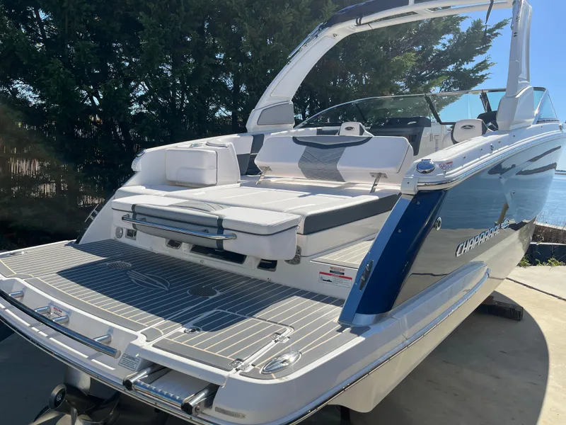 Slide: The Image of 2019 Chaparral 277 SSX boat with spacious deck and seating, docked near water. - 12
