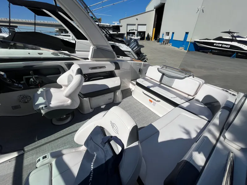 Slide: The Image of 2019 Chaparral 277 SSX boat interior with seating and helm, docked at marina. - 15