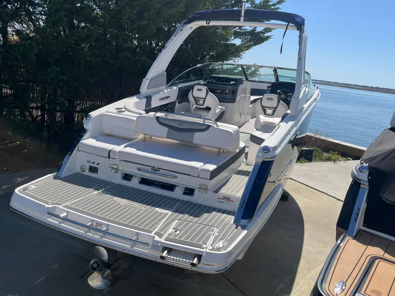 Slide: The Image of 2019 Chaparral 277 SSX boat with spacious seating, docked by the water. - 2