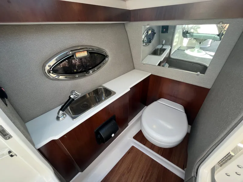 Slide: The Image of 2019 Chaparral 277 SSX boat bathroom with sink, toilet, and mirror. - 21