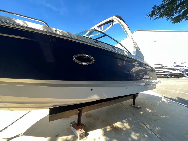 Slide: The Image of 2019 Chaparral 277 SSX boat with sleek blue and white design, docked outdoors. - 3