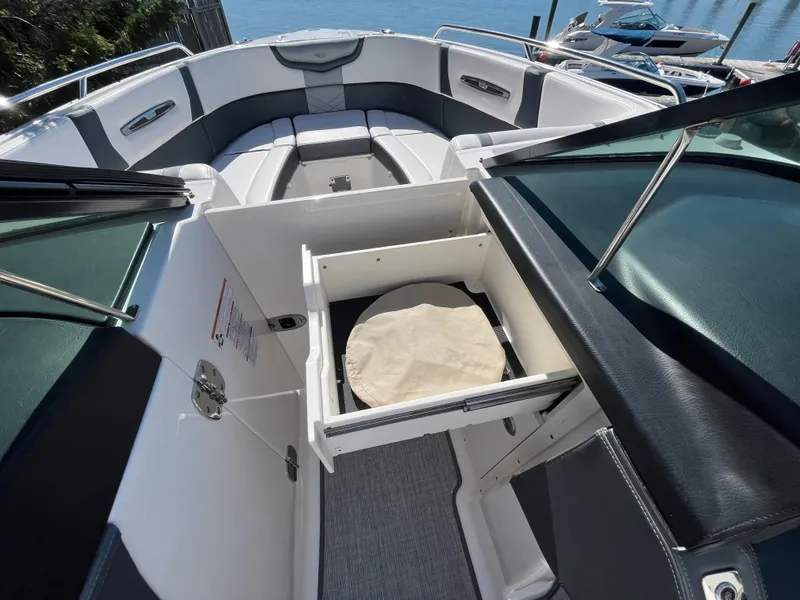 Slide: The Image of 2019 Chaparral 277 SSX boat interior with open storage compartment and seating area. - 32