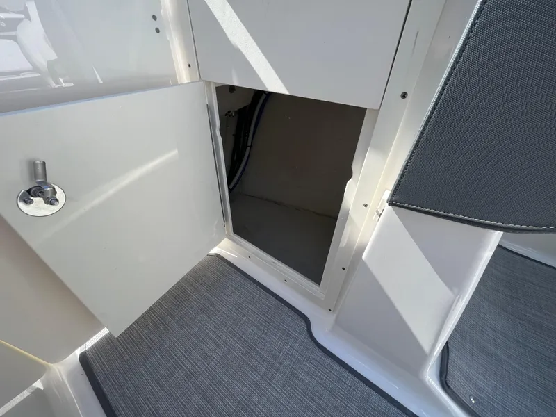 Slide: The Image of 2019 Chaparral 277 SSX boat storage compartment with open door, showcasing interior space. - 33