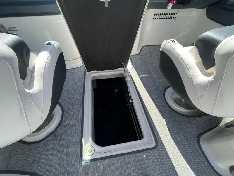 Slide: The Image of 2019 Chaparral 277 SSX boat interior with open storage compartment between seats. - 39