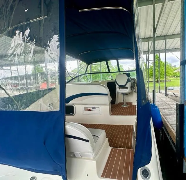 Slide: The Image of 1998 Rinker Fiesta Vee 266 boat interior with blue canopy and seating. - 10