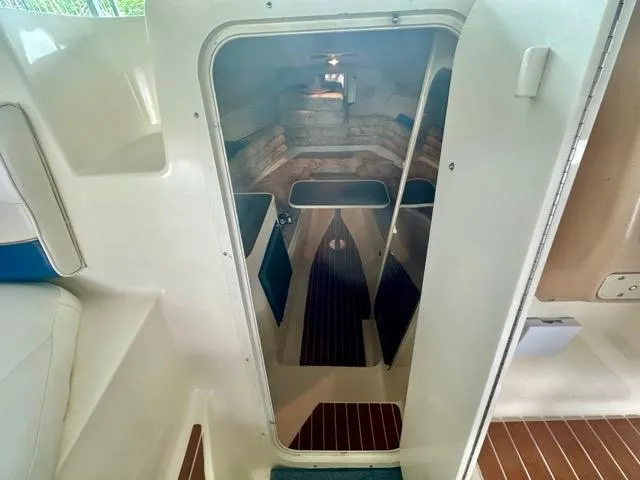 Slide: The Image of 1998 Rinker Fiesta Vee 266 cabin interior with seating and wood accents. - 13