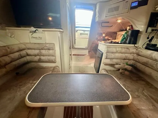 Slide: The Image of Interior of a 1998 Rinker Fiesta Vee 266 boat with seating and table. - 18