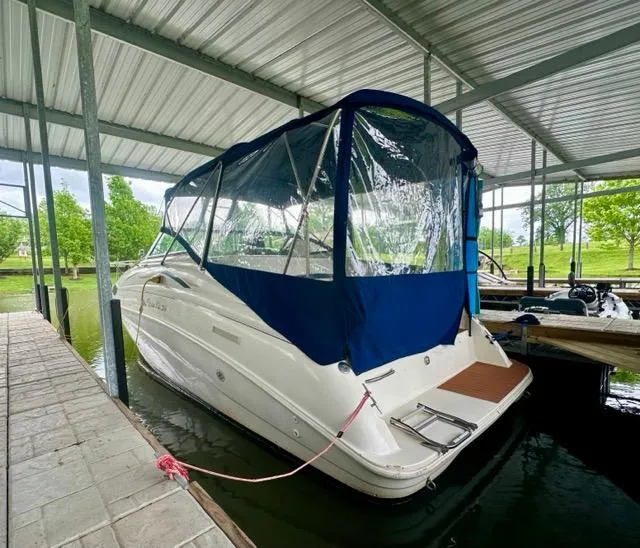Slide: The Image of 1998 Rinker Fiesta Vee 266 boat docked under covered marina. - 2