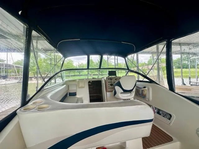 Slide: The Image of 1998 Rinker Fiesta Vee 266 boat interior with seating and helm under canopy. - 8
