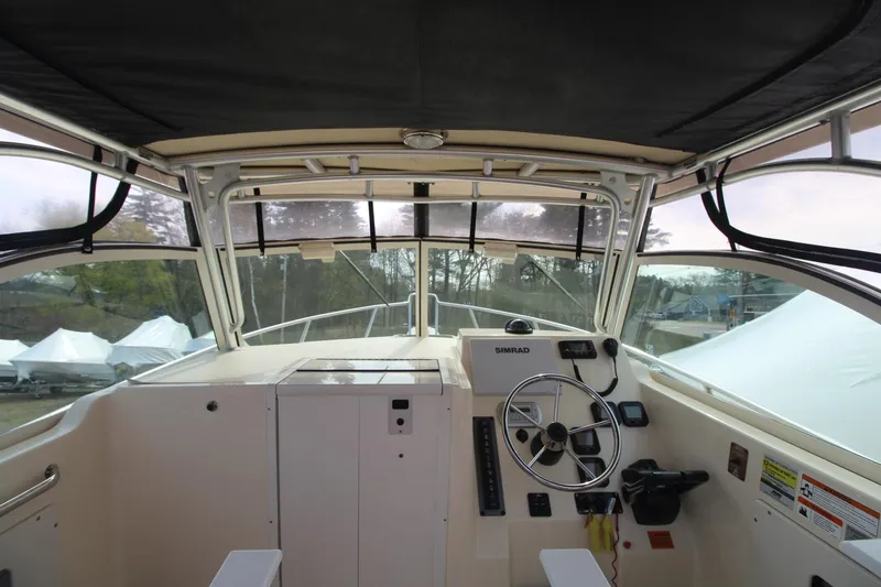 Slide: The Image of 2012 Parker 2510 XLD Walkaround boat interior with steering wheel and controls. - 10