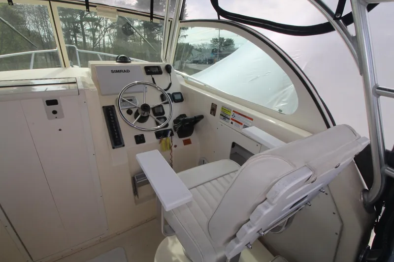 Slide: The Image of 2012 Parker 2510 XLD Walkaround boat cockpit with steering wheel and controls. - 8