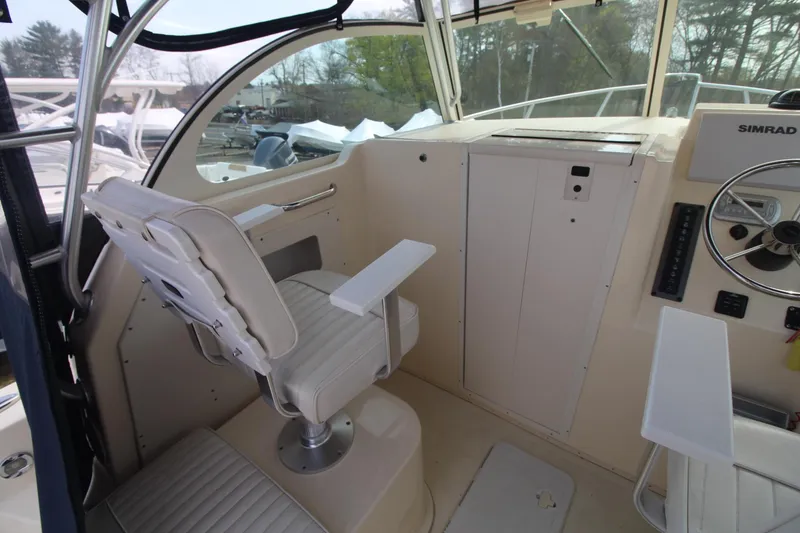Slide: The Image of 2012 Parker 2510 XLD Walkaround boat cockpit with helm seat and steering wheel. - 9
