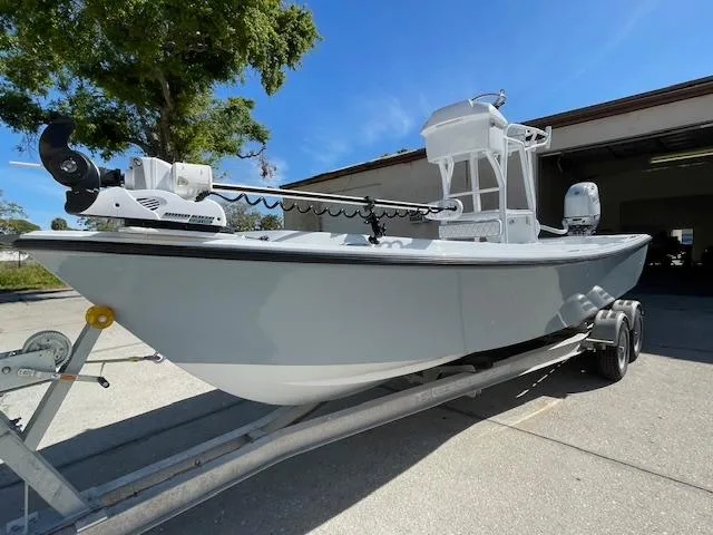 Slide: The Image of 1986 Aquasport Tournament 222 boat on trailer, parked outdoors under clear blue sky. - 0
