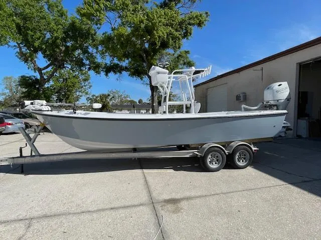 Slide: The Image of 1986 Aquasport Tournament 222 boat on trailer, parked outdoors under clear blue sky. - 1