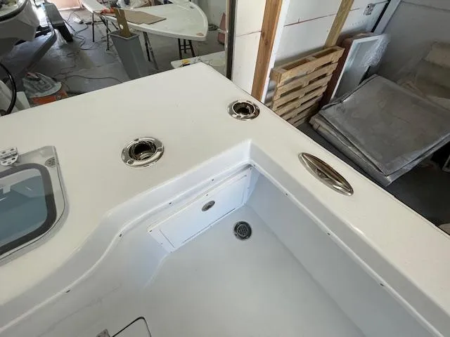 Slide: The Image of 1986 Aquasport Tournament 222 boat interior with rod holders and storage compartment. - 16