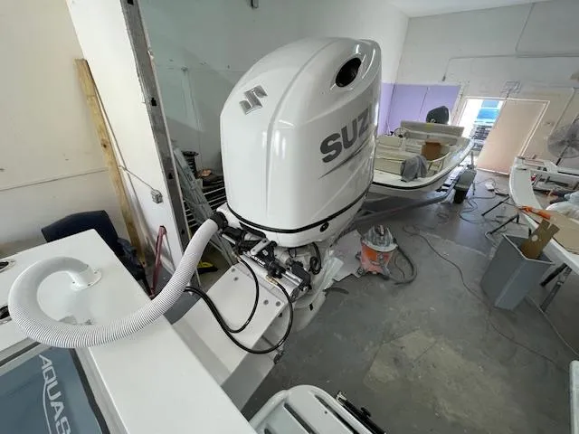 Slide: The Image of 1986 Aquasport Tournament 222 boat with Suzuki outboard motor in a workshop. - 17