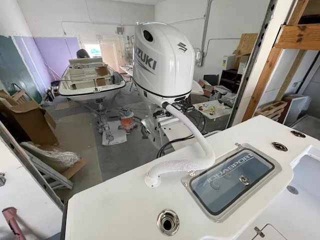 Slide: The Image of 1986 Aquasport Tournament 222 boat with Suzuki outboard motor in a workshop setting. - 18