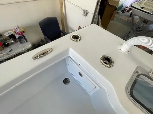 Slide: The Image of 1986 Aquasport Tournament 222 boat interior with rod holders and storage compartment. - 23