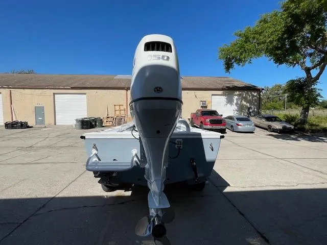 Slide: The Image of 1986 Aquasport Tournament 222 boat with outboard motor in a sunny parking lot. - 4
