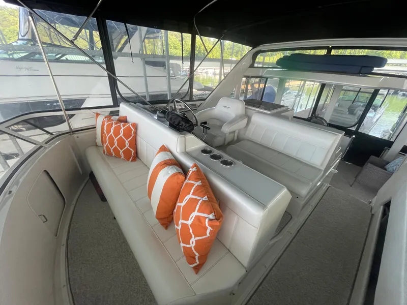 Slide: The Image of 1998 Carver 405 Aft Cabin interior with white seating and orange pillows. - 10