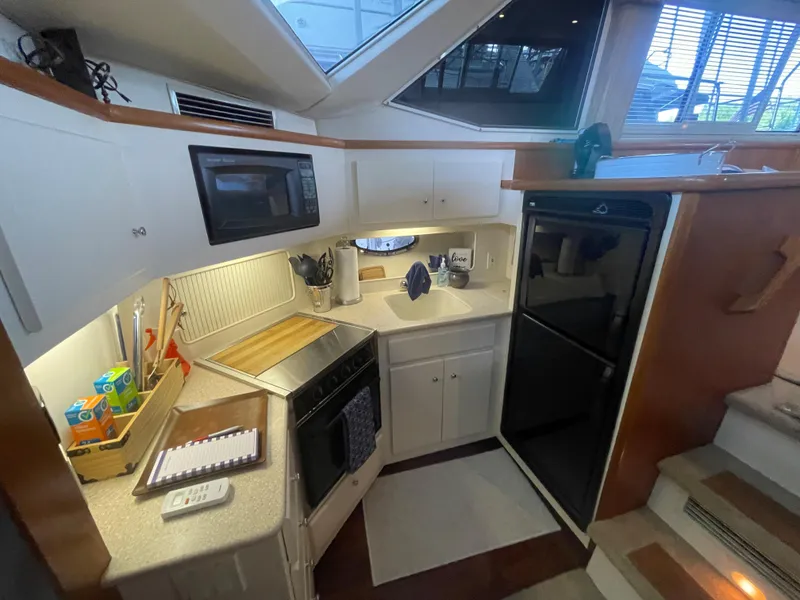Slide: The Image of 1998 Carver 405 Aft Cabin kitchen with microwave, stove, and refrigerator. - 11