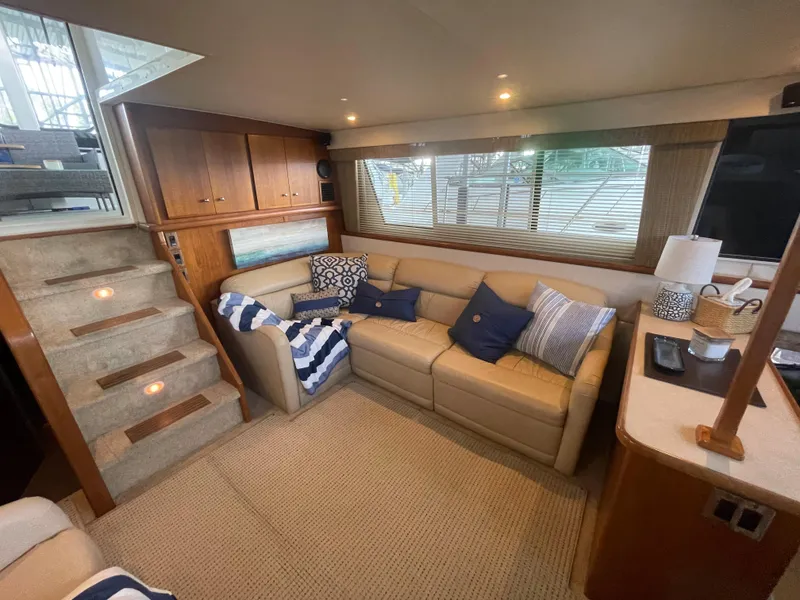 Slide: The Image of 1998 Carver 405 Aft Cabin interior with cozy seating, nautical decor, and ambient lighting. - 12