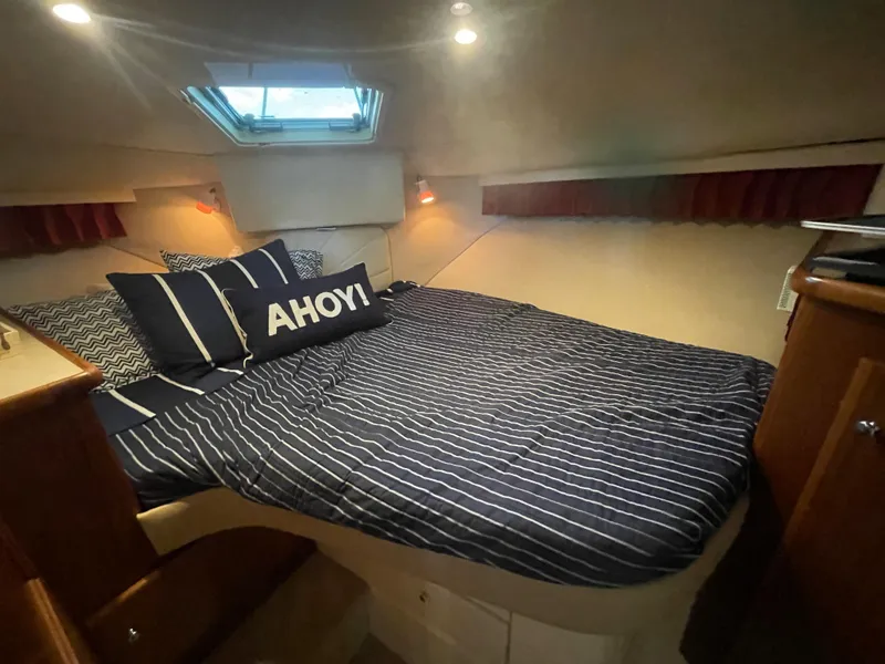 Slide: The Image of Cozy cabin interior of 1998 Carver 405 Aft Cabin with nautical-themed bedding. - 13