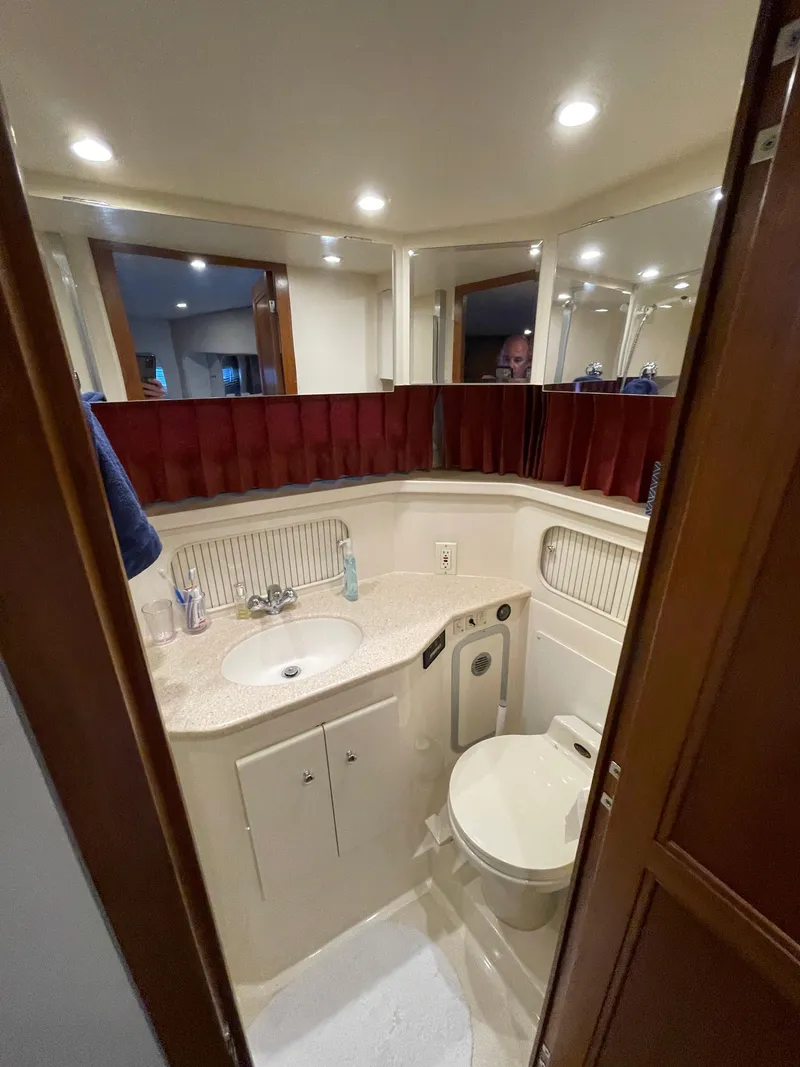 Slide: The Image of 1998 Carver 405 Aft Cabin bathroom with sink, toilet, and mirror. - 15