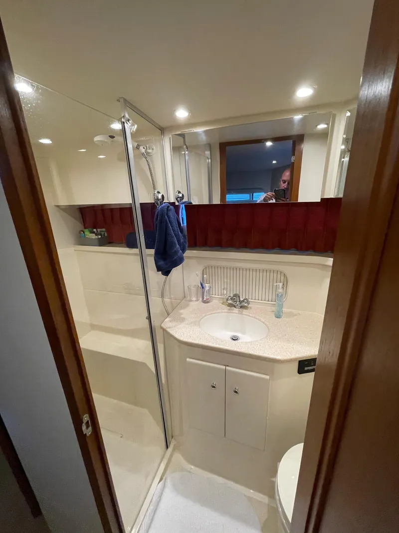 Slide: The Image of 1998 Carver 405 Aft Cabin bathroom with shower, sink, and mirror. - 18