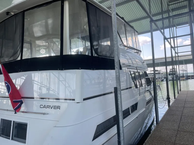 Slide: The Image of 1998 Carver 405 Aft Cabin yacht docked under a covered marina. - 4