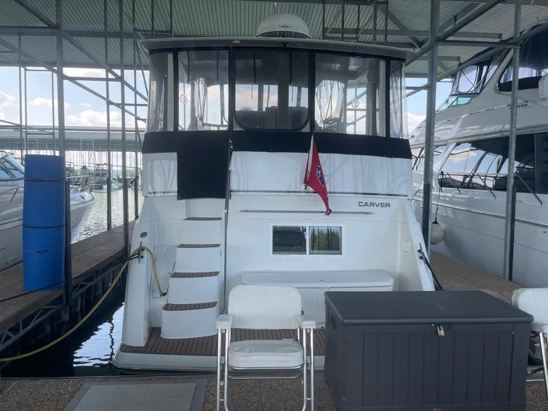 Slide: The Image of 1998 Carver 405 Aft Cabin yacht docked in marina, rear view. - 5