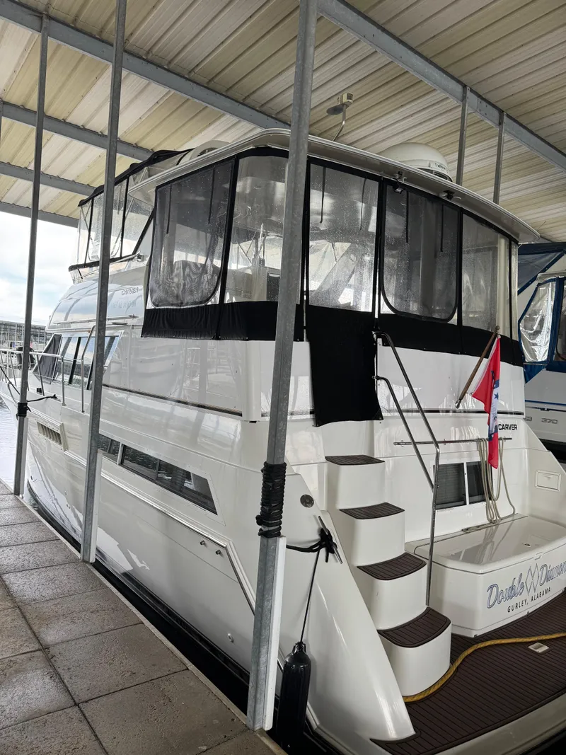 Slide: The Image of 1998 Carver 405 Aft Cabin yacht docked under a covered marina. - 7